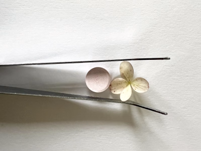 Pincet met bloem en pil